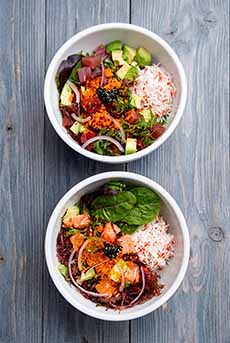 A salmon poke bowl with crab leg and avocado.