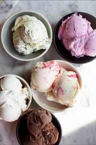 Bowls of 5 different flavors of ice cream.
