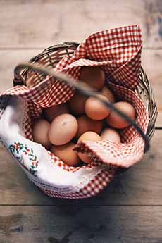 Basket Of Brown Eggs On A Red Gingham Napkin