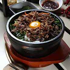 A stoneware bowl of Korean Bibimbap