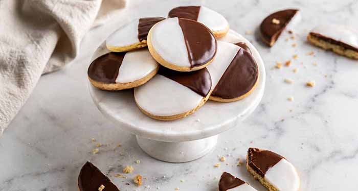Black and white cookies on a pedestal plate.