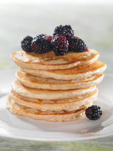 A Stack Of Pancakes Topped With Blackberries