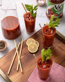 A pitcher and glasses of Bloody Marys made with V8 vegetable juice