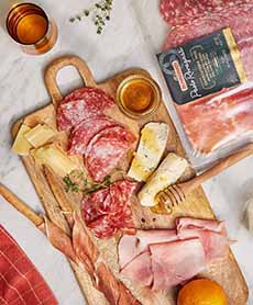 A wood serving board laden with salume, Italian charcuterie.