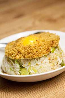 Fried rice topped with a fried egg dipped in panko crumbs.