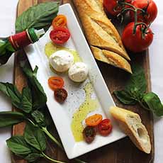 A Platter Of Burrata Cheese With Basil & Tomatoes