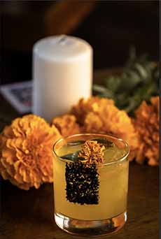 A Mezcal Cocktail With Fresh Geranium Flower Garnish