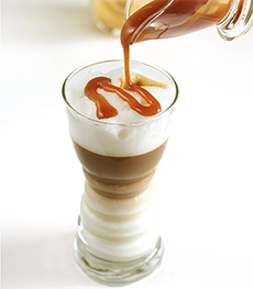 Pouring caramel syrup onto a macchiato espresso.