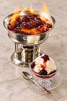 A chafing dish with flaming Cherries Jubilee.
