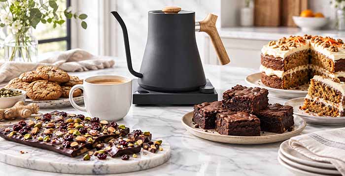 A chai tea party buffet with cookies, chocolate bark, brownies, and carrot cake.