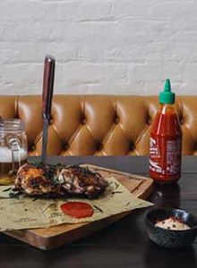 A Bottle Of Sriracha Sauce With Roast With Chicken