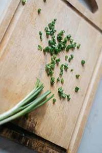 Minced Chives On Cutting Board With A Knife