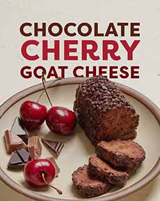 A Plate Of Chocolate Cherry Goat Cheese With Fresh Cherries & Pieces Of Chocolate Bars