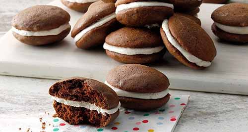 A plate of chocolate whoopie pies with vanilla cream filling.