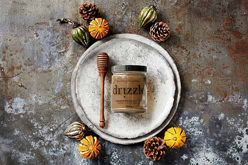 A Jar Of Drizzle Honey With A Honey Dipper