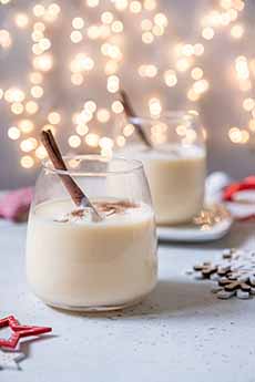 2 cups of eggnog with festive holiday lights