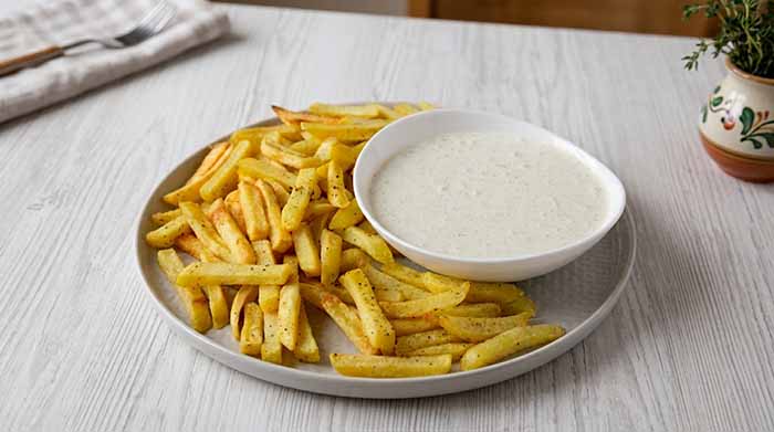A Plate Of Fries With Ranch Dressing