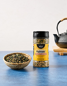 A jar and bowl of furikake Japanese seasoning blend.