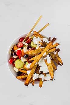 Greek Salad Topped With French Fries