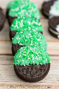 St. Patricks Day Oreos, dipped in green-colored white chocolate and topped with sprinkles