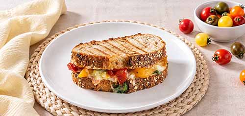Grilled cheese sandwich with cherry tomatoes and basil.
