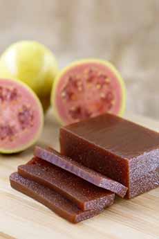 Slices Of Guava Paste Shown With Fresh Guavas
