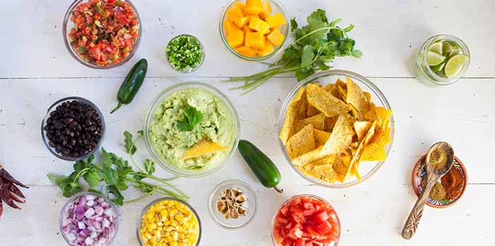 A bowl of guacamole with different toppings.