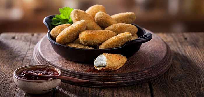 A plate of jalapeno poppers with pepper jelly.