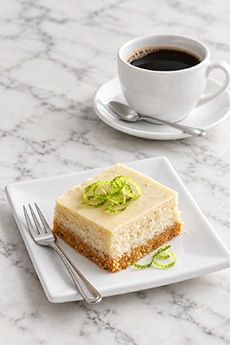 A Key lime bar with a cup of coffee.
