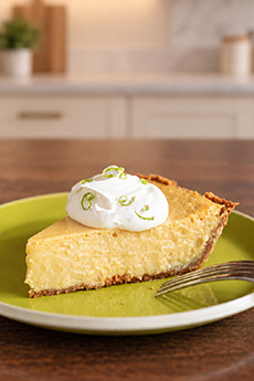 A slice of Key lime pie with a dollop of whipped cream.