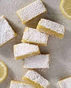 A platter of lemon bars, topped with confectioner's sugar.