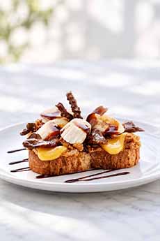 A bacon and banana grilled cheese sandwich with a drizzle of fudge sauce.