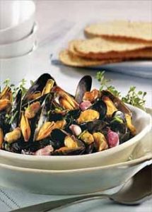 A bowl of steamed mussels in garlic butter sauce