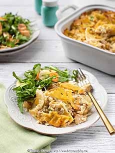 Noodle kugel on a plate with green salad