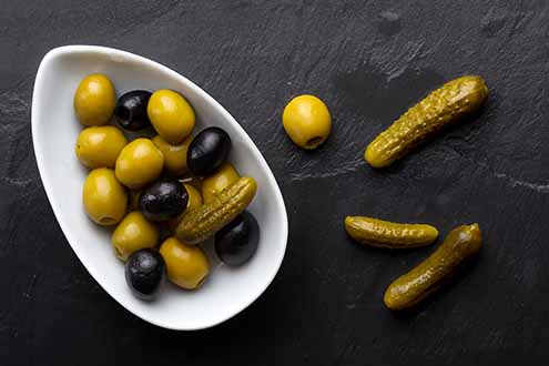 Dish of mixed olives and cornichons