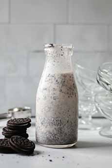 A glass of Oreo milk with Oreo cookies
