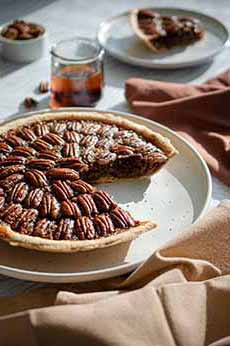 A pecan pie with a slice removed.