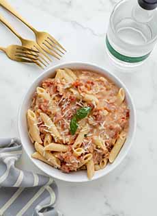 A bowl of penne in tomato cream sauce