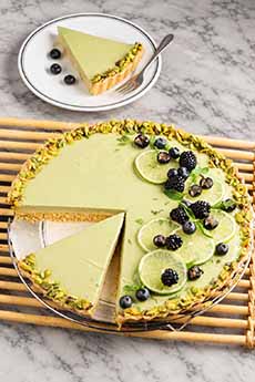 Key lime tart garnished with blackberries and black currants.