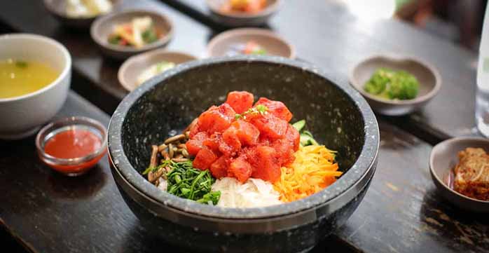 A Korean-style poke bowl with small bowls of banchan.