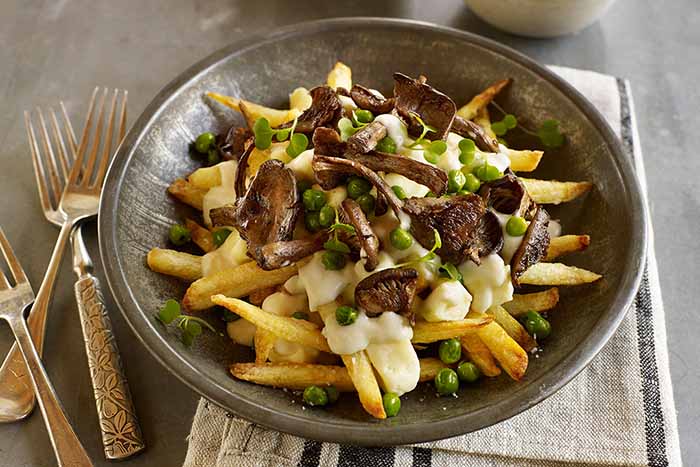 A Dish Of Poutine With Mushrooms & Peas Added
