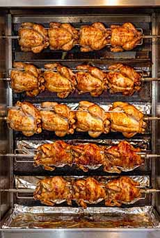 Five racks of rotisserie chickens.