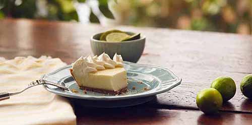 A slice of Key lime pie garnished with whipped cream.