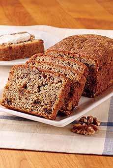 A sliced loaf of date nut bread on a plate.