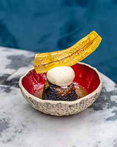 A fancy Sticky Toffee Pudding presentation with a plantain chip garnish