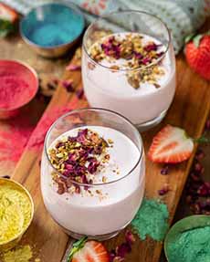 Glasses Of Strawberry Lassi Garnished With Rose Petals & Pistachio Nuts