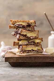 A grilled truffle cheese and porchetta sandwich on sourdough toast.