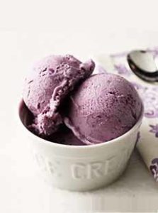 A dish of ube ice cream. The dish is white, the ice cream is purple.