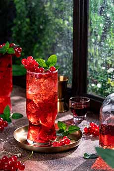A Vodka Cranberry cocktail on a holiday-decorated tabletop.