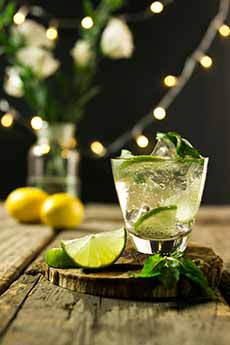 A vodka soda drink with a lime wedge.